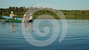 Young family sails in a green wooden boat