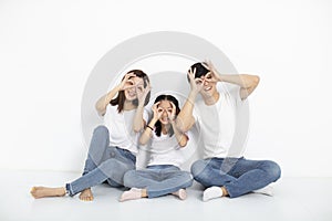 Young family sitting on floor with looking gesture