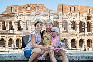 Young Family Sitting In Front Of Colosseum