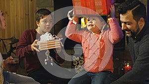 Young family giving each other Christmas gifts