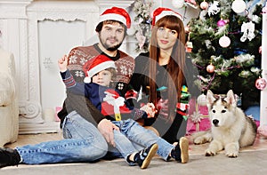 Young family sitting under the Christmas tree