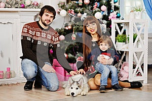 Young family sitting under the Christmas tree