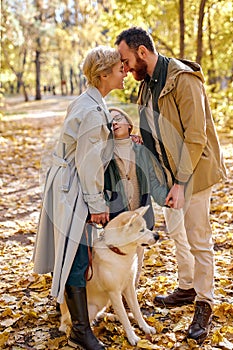 Young family spend autumn weekends outdoors, walking together in forest