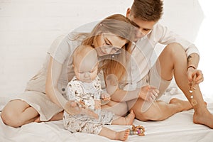 Young family spending time together, mother father baby, playing toys. Attention deficit disorder. Hugging and caring