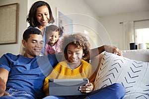 Young family spending time together using a tablet computer in their living room, front view