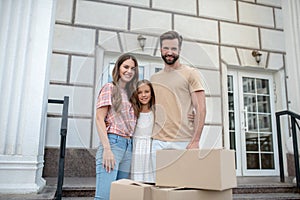 Young family standing near boxes and smiling