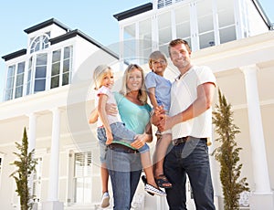 Young Family Standing Outside Dream Home