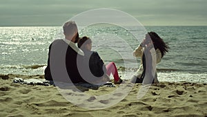 Young family taking pictures on sunny day beach. Mom dad child photographing sea