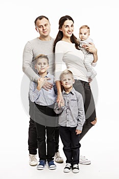 Young family with three children smiling and hugging. Full height. Love and tenderness. White background.