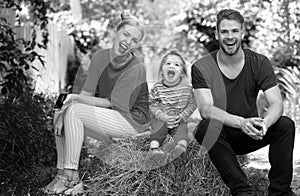 Young family of three having fun together launching. Funny parents playing with son smiling outdoor. Father mother and