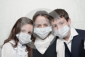 Young family of three little kids in medical masks and school uniform during coronavirus COVID-19 epidemy quarantine photo