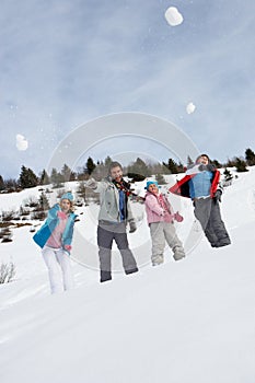 Young Family Throwing Snowballs On Winter Vacation photo