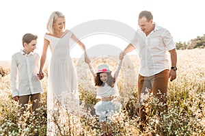 Young family with two children holding hands