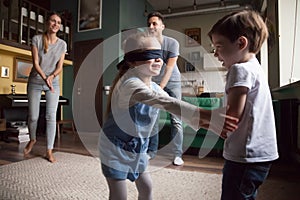 Young family with two children playing hide-and-seek photo