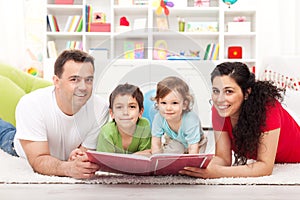 Young family with two kids reading a story book