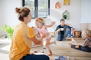 Young family with two small children indoors in bedroom playing. photo