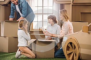 young family unpacking boxes while moving into new