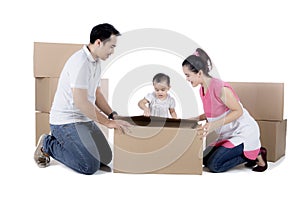 Young family unpacking cardboard on studio