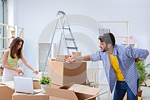 The young family unpacking at new house with boxes