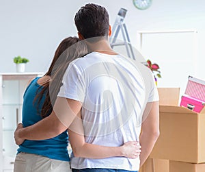 Young family unpacking at new house with boxes