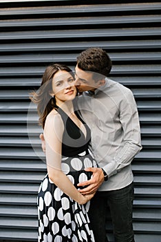 Young family waiting for the unborn child. A husband holds his hand on his wife`s stomach