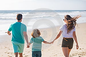 Young family walking on beach. Young happy family having fun together at the sea beach.