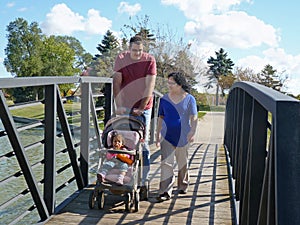 Young family walking on bridge.