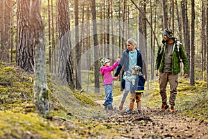 Young family walking and exploring the forest with children. nature adventures