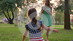 Young family is walking in park in summer, daughter is catching bubbles, childhood concept