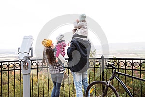 Young family in warm clothes with bicycle in autumn park