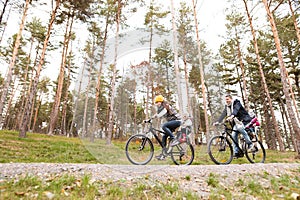 Young family in warm clothes cycling in autumn park