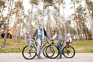 Young family in warm clothes cycling in autumn park