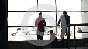 Young family watching planes at an airport