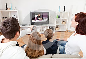 Young family watching TV at home photo