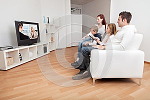 Young family watching TV at home