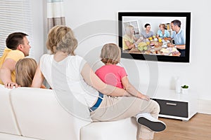 Mladý rodina sledování televize společně 