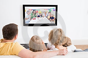 Young family watching tv together photo