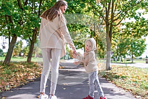 Young family, woman mom holds hand of her son, little boy turns around and looks back. Emotions of joy, smile and