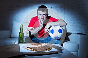 Young fan man watching football game on tv in team jersey suffering nervous and stress