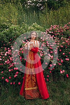 Young fantasy princess in roses garden