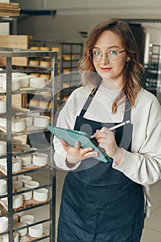 Young Farm Female Owner Controls Maturing Process of Goat Cheese Heads