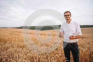 young farmer engineer standing on wheat field