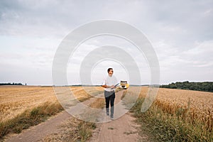 young farmer engineer standing on wheat field.