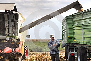 Young farmer examine corn seed in corn fields