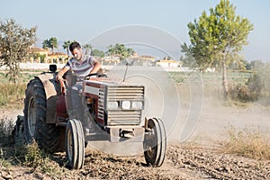 Young farmer ploughing the field in his tractor