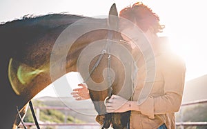 Young farmer woman hugging her horse - Concept about love between people and animals - Focus on pet face
