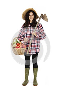 Young farmer with work tools and basket with vegetables and fruit