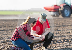 Young farmers examing planted wheat fields