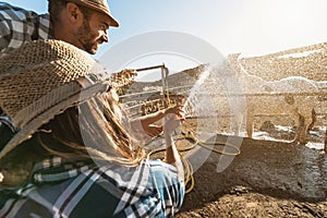 Young farmers washing horse inside corral ranch