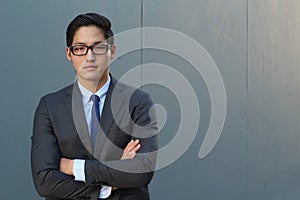 Young fashion Asian man wearing suit, tie and glasses with space for copy